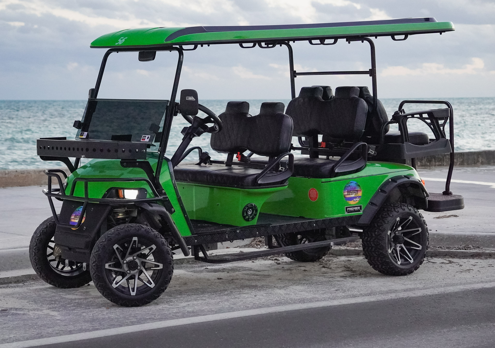 Lime green golf cart by the ocean