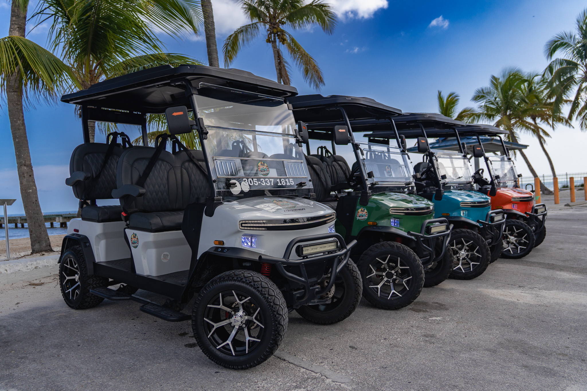 Four colorful golf carts in a row