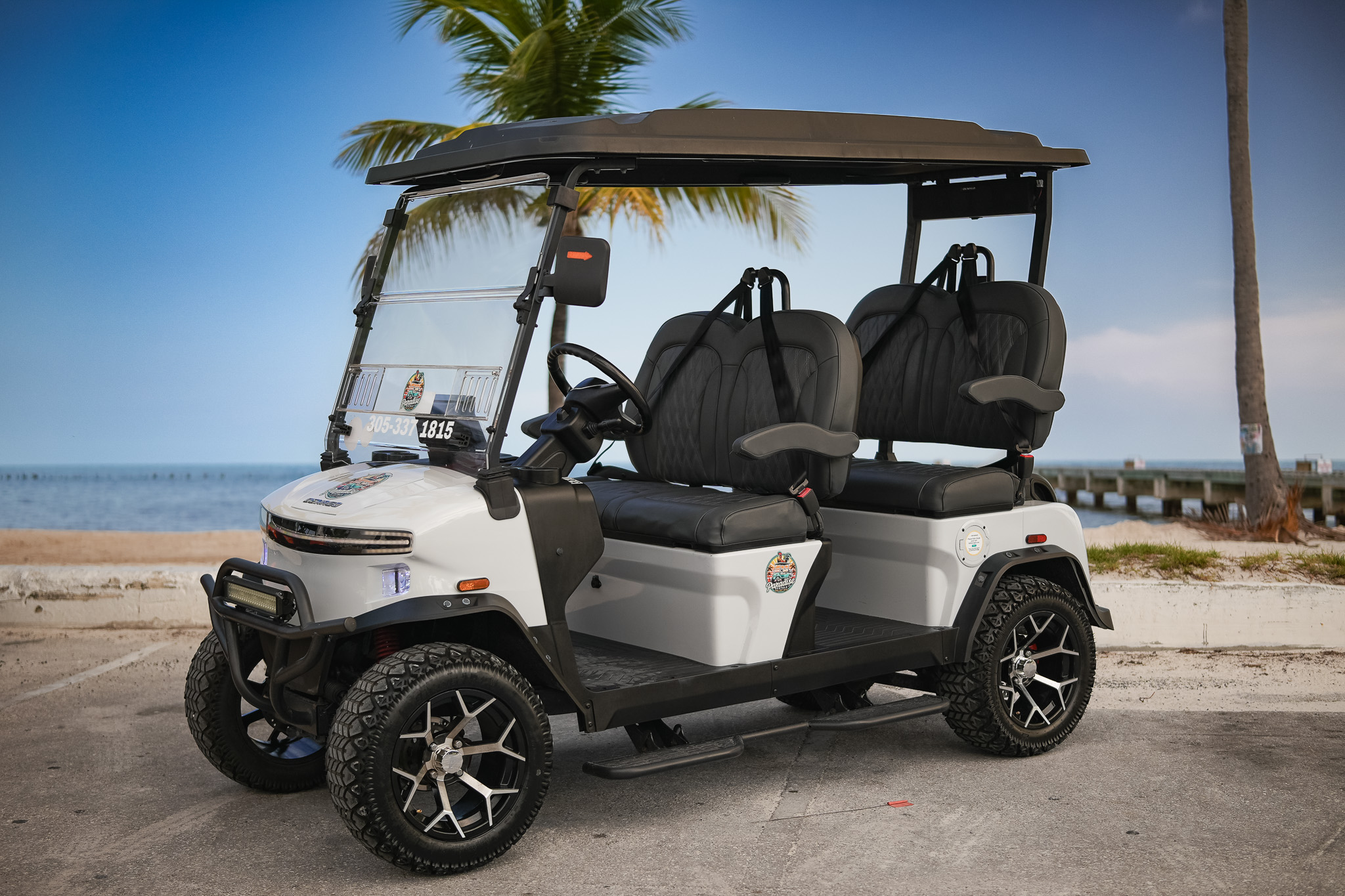 White Denago golf cart at the beach